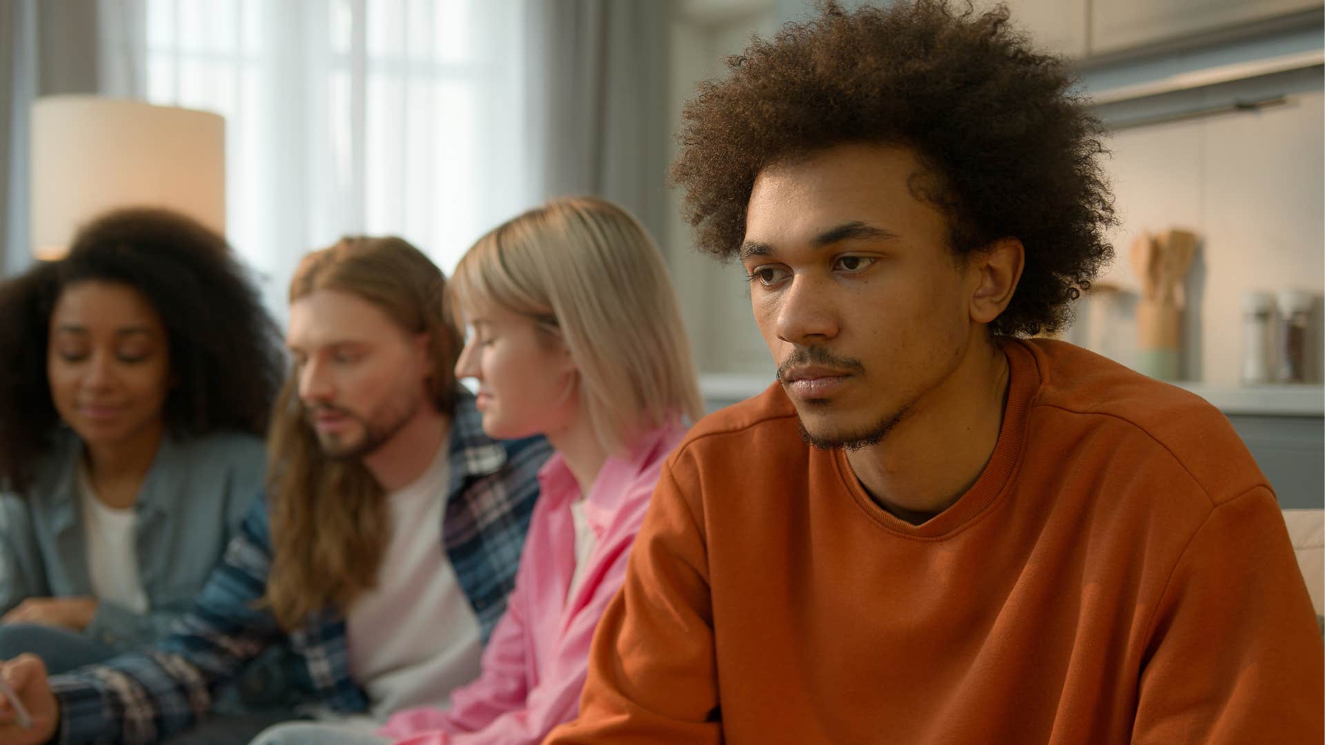 man hiding from friends during social event