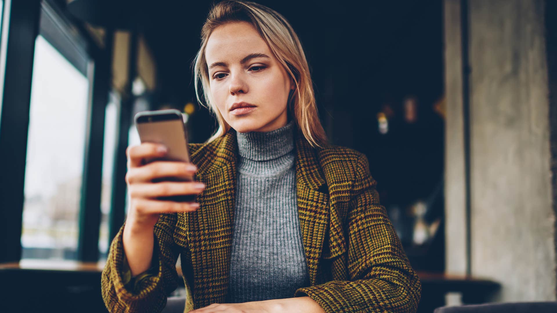 woman who's stopped responding to texts looking at her phone