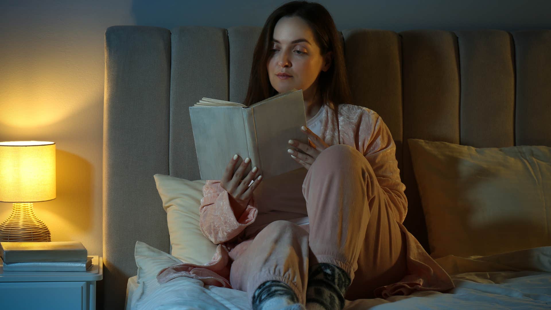 Woman who appreciates the structure of routine reading in bed.