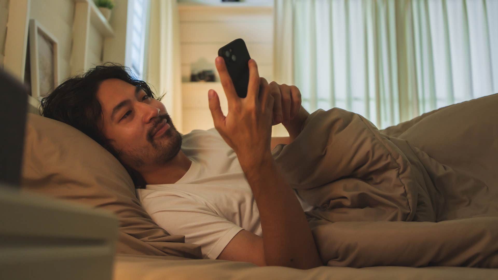Man who's intentional about his space sitting in bed.