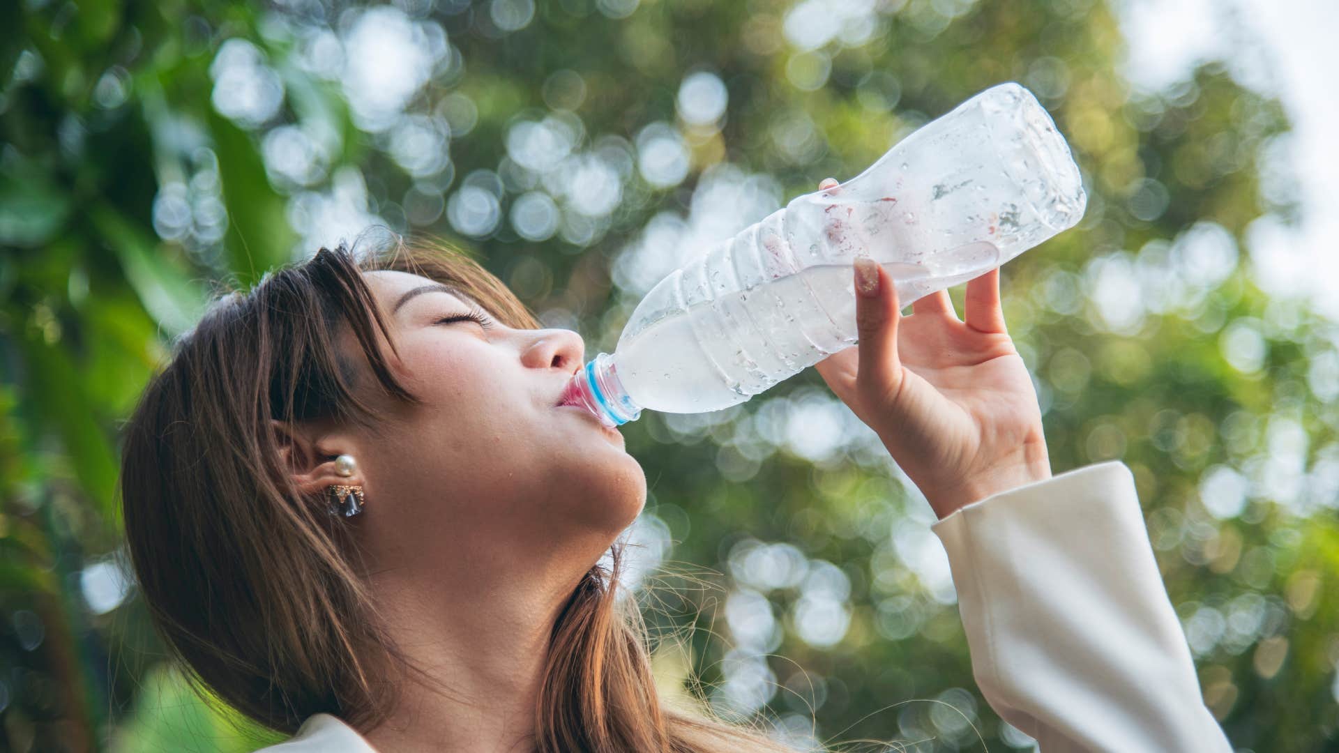 if you grew up broke but made it, you still probably can't bring yourself to buy these simple things fancy water bottle woman drinking water from bottle