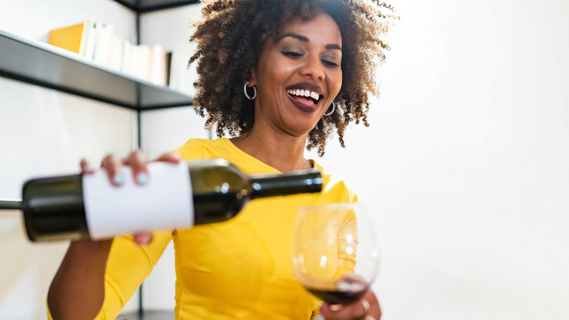 if you grew up broke but made it, you still probably can't bring yourself to buy these simple things nice bottle of wine woman pouring expensive wine into glass
