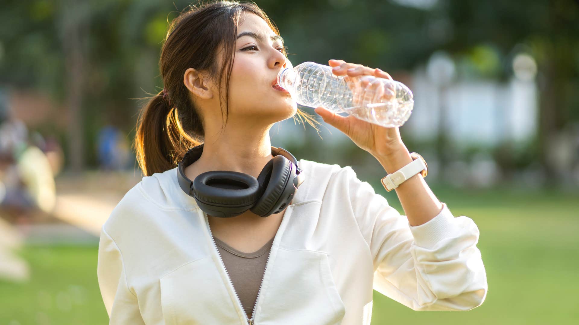 woman drinking bottled water outside