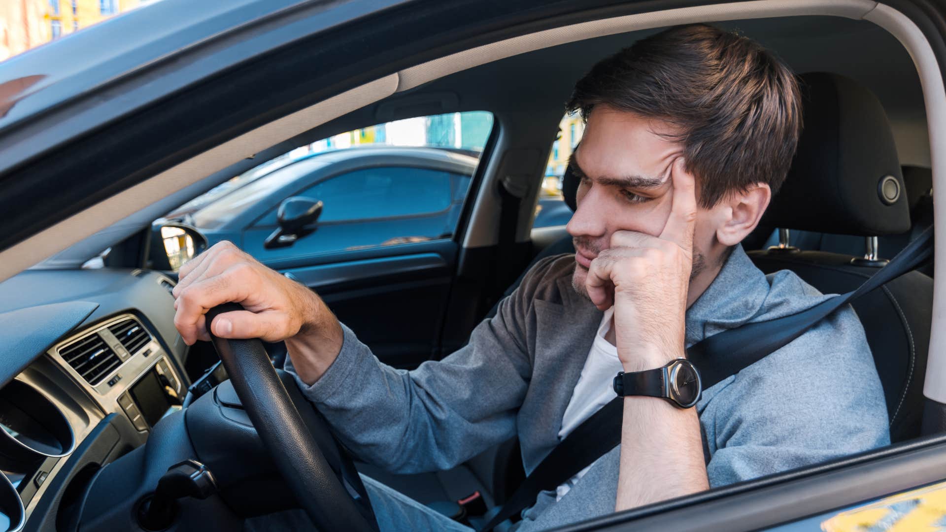 man frustrated looking for parking while driving