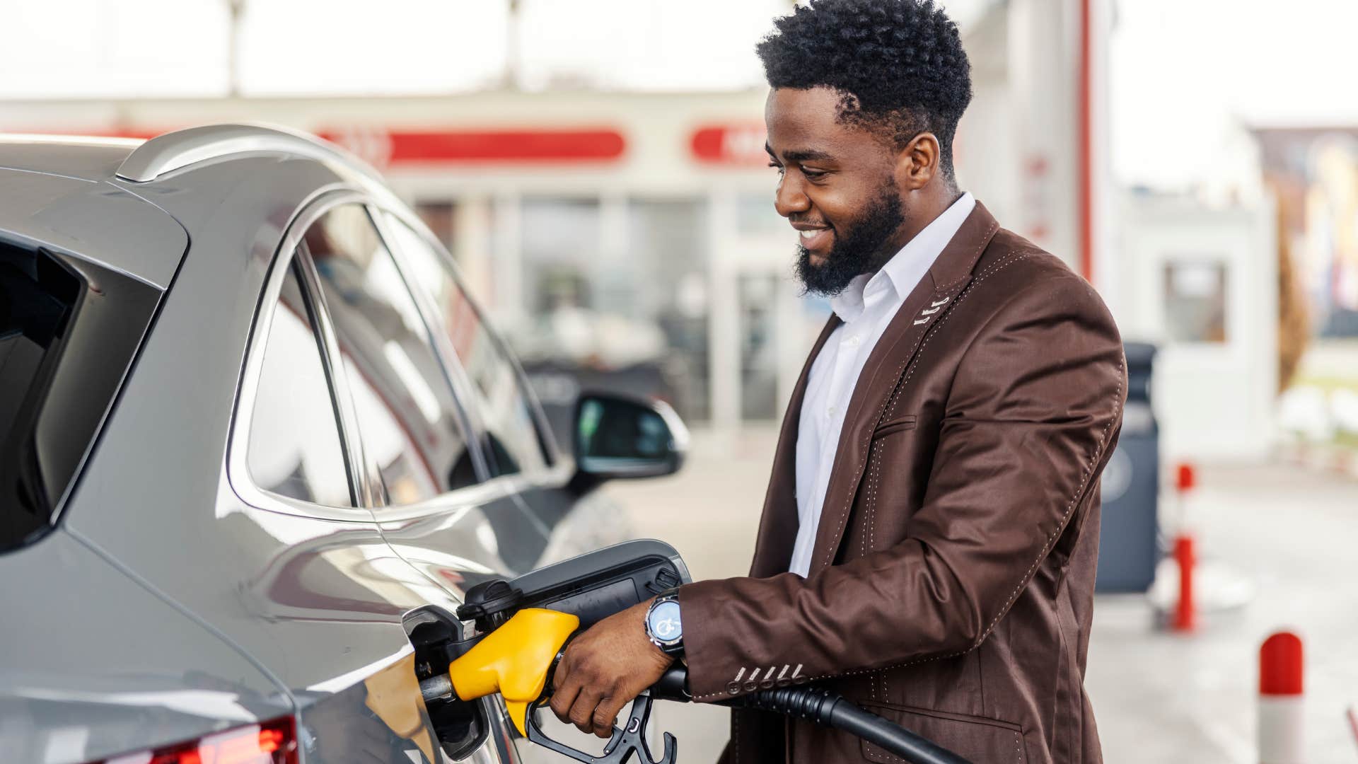 man putting fuel into his car at the gas station