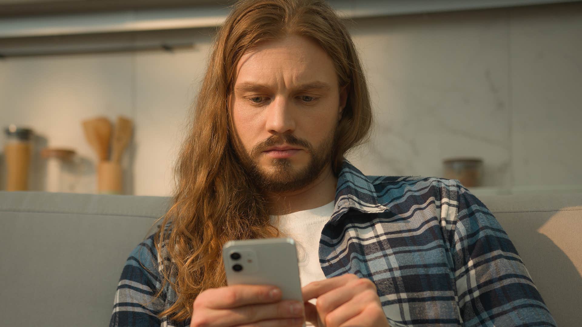 man who's selective about socializing looking at his phone