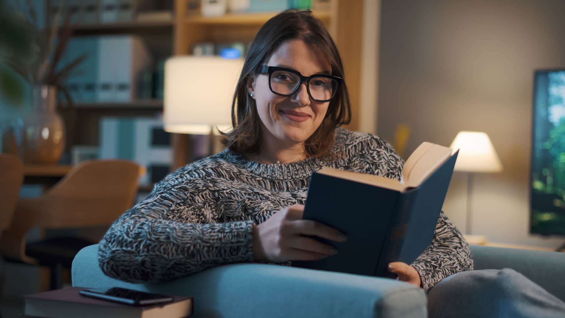 woman who's outgrown her people-pleasing tendencies reading at home