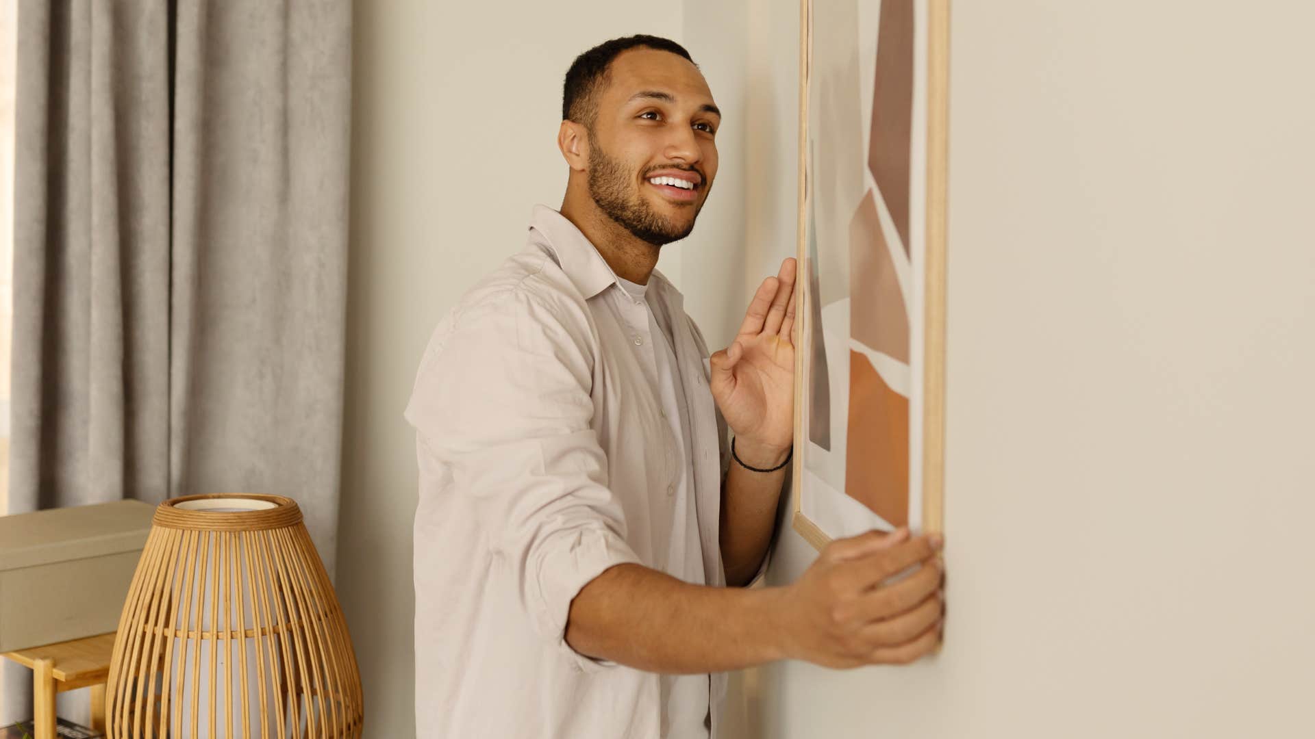 decorative items if you notice these things missing from someone's home they've probably been through a lot in life man putting up decorative photo at home