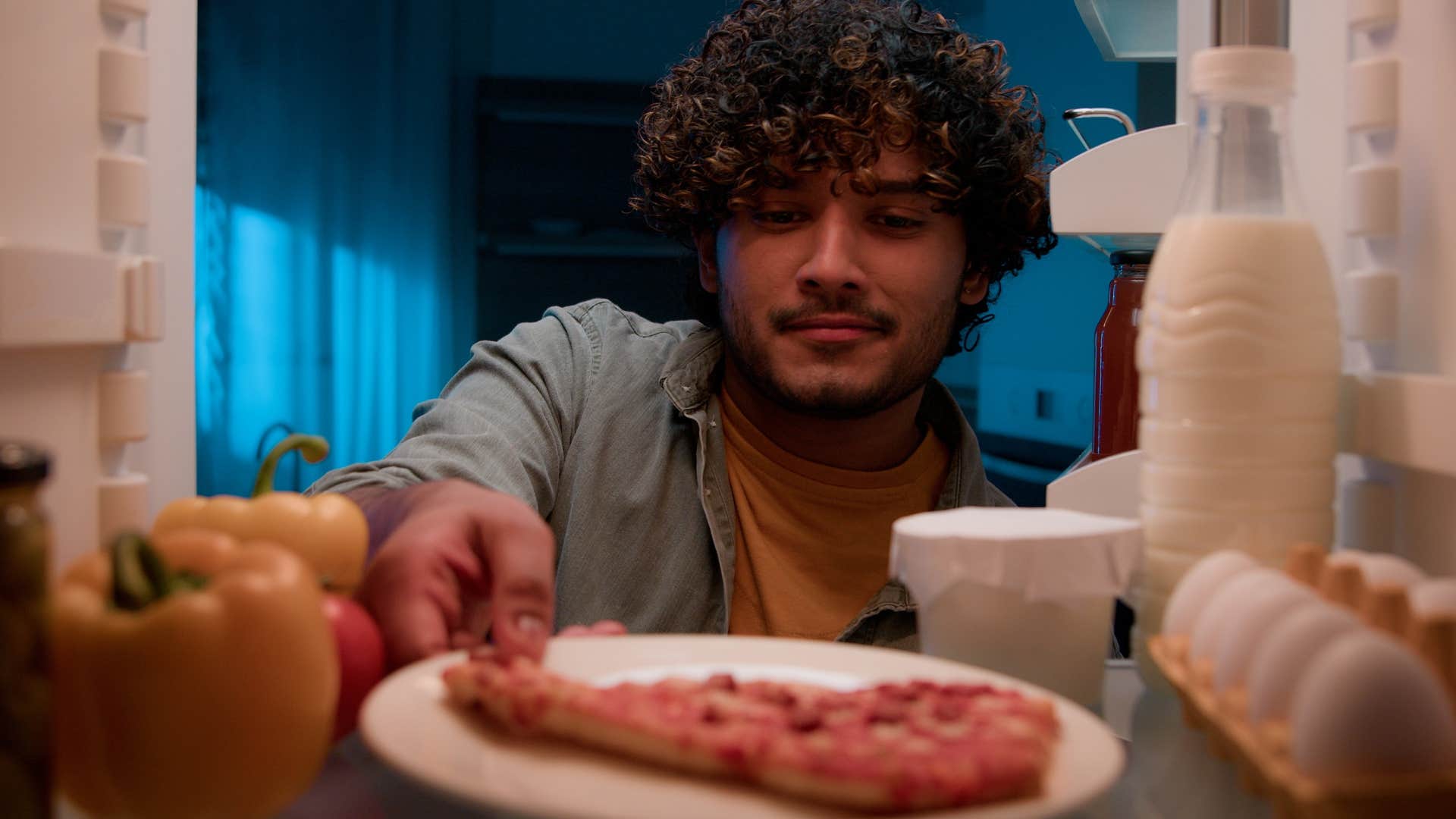 tons of food options if you notice these things missing from someone's home they've probably been through a lot in life man looking at tons of food options in his fridge