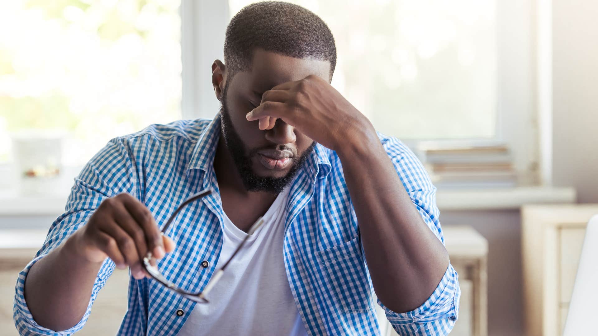 Man who's rushing around and stressed sitting at his desk.