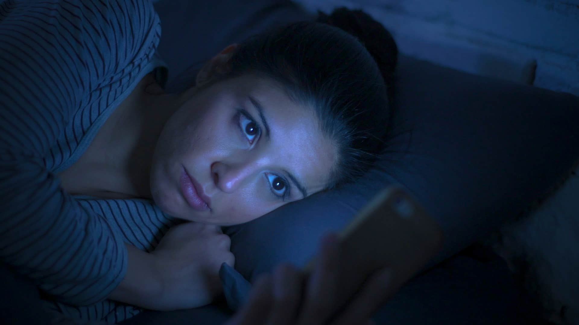 Woman whose mornings are full of anxiety looking at her phone.
