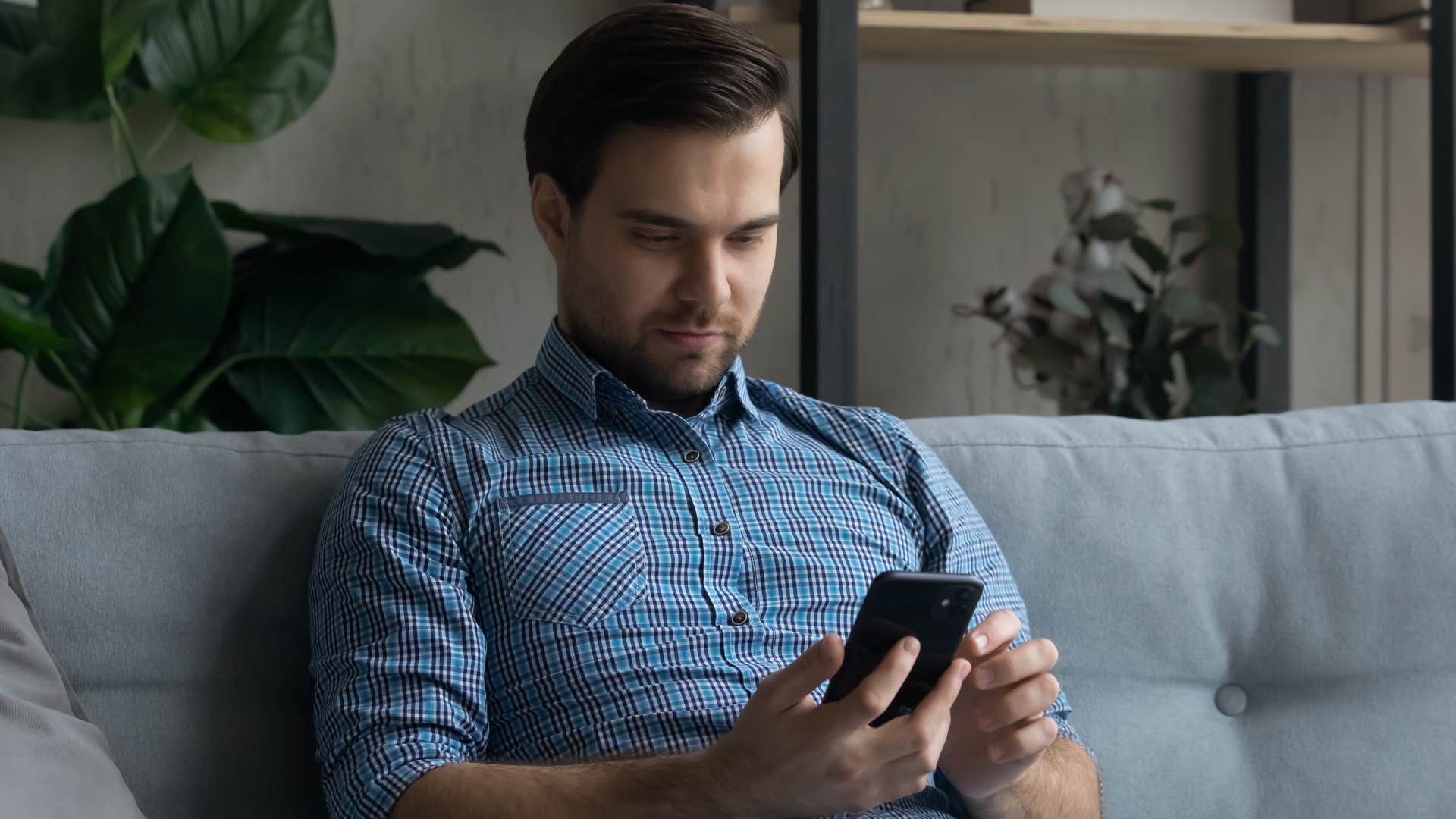 Man who knows that silence feels uncomfortable looking at his phone.