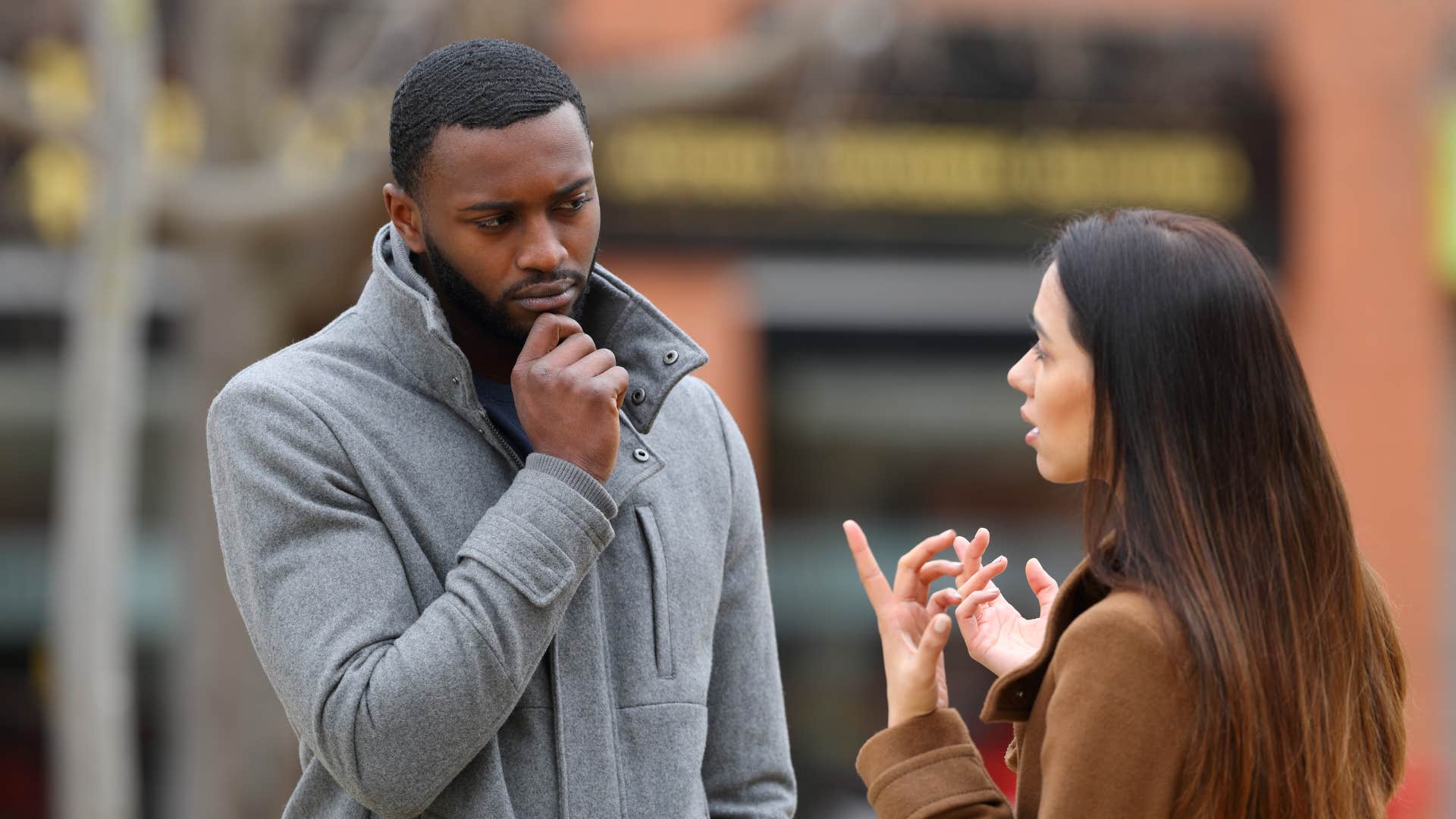 woman in brown jacket telling man wisdom is chasing you but you're faster as he looks confused
