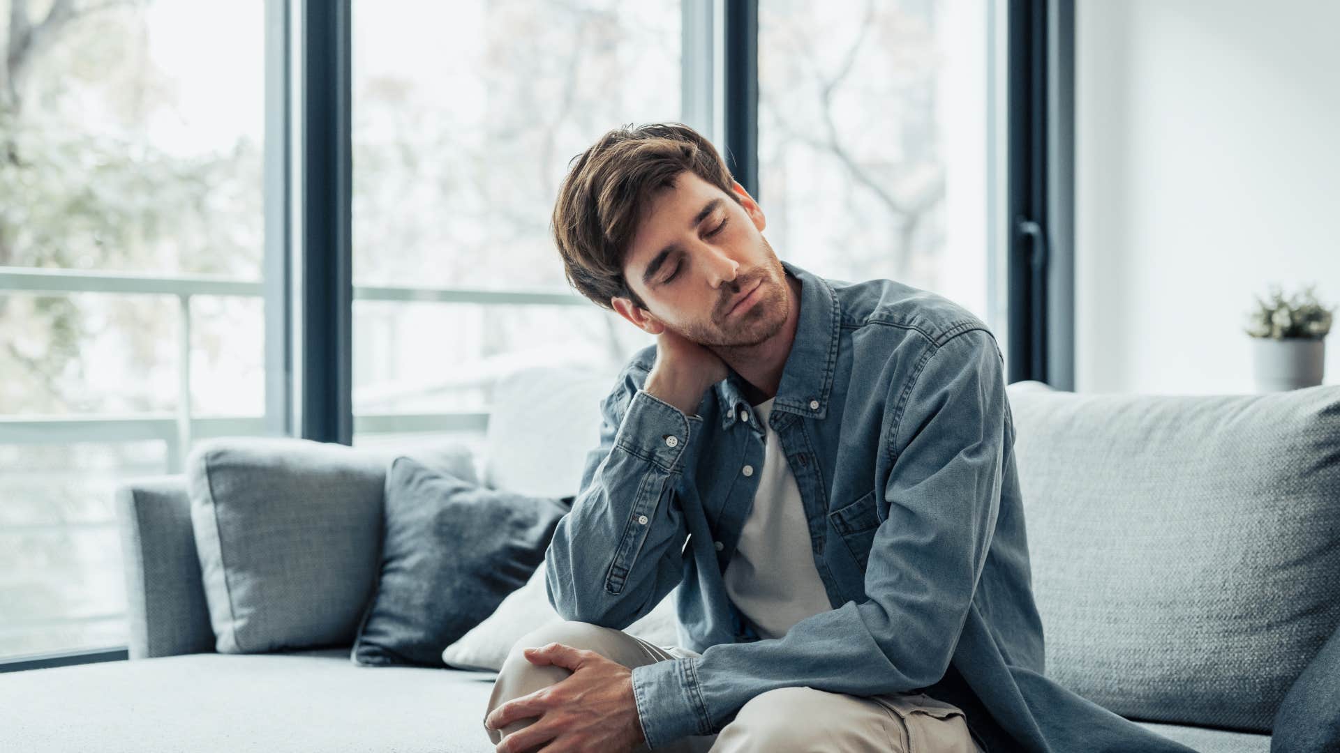 men who are afraid of falling in love often do these self-sabotaging things pull away when things start to get real upset man sitting on couch