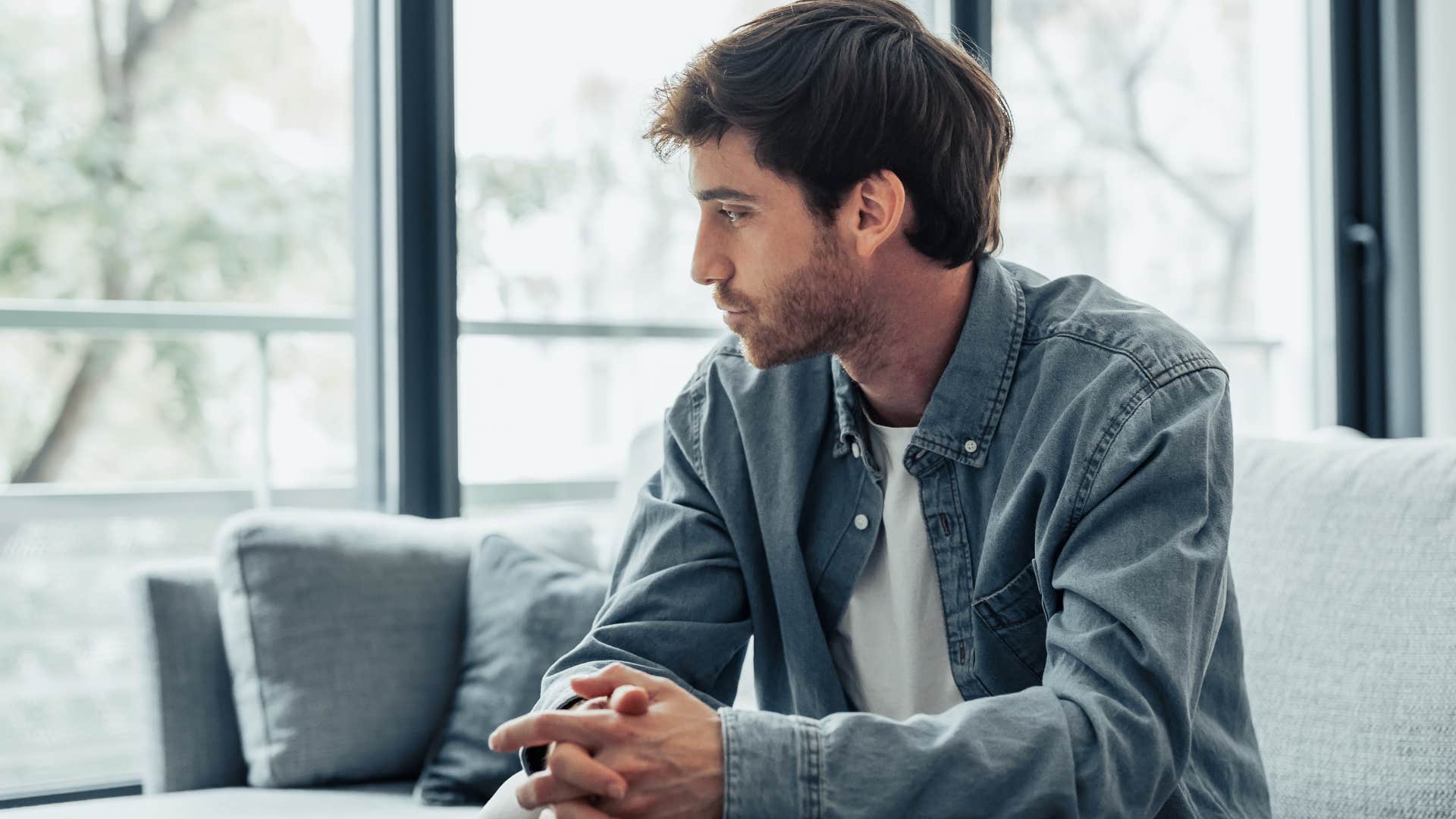Man who tries to be perfect sitting on the couch.