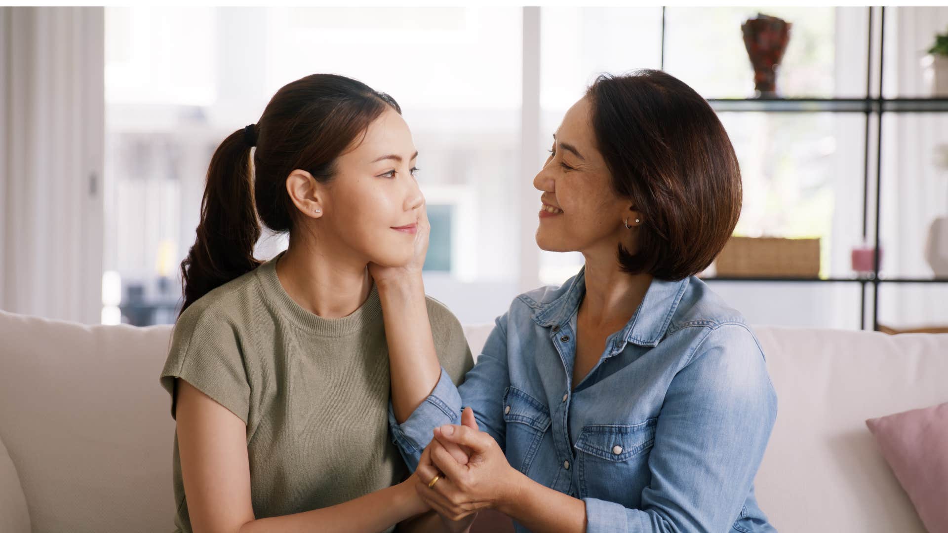 mom making daughter feel safe holding her cheek