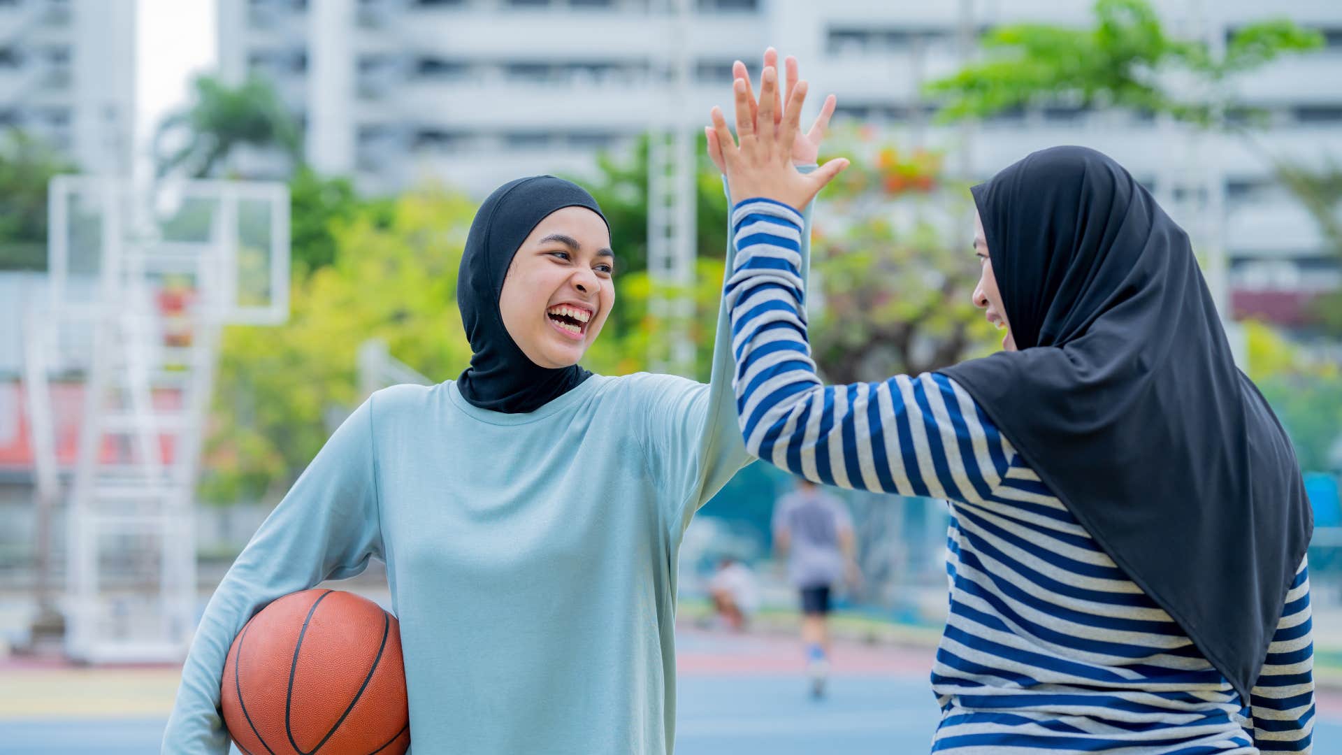 mom high-fiving daughter with basketball 