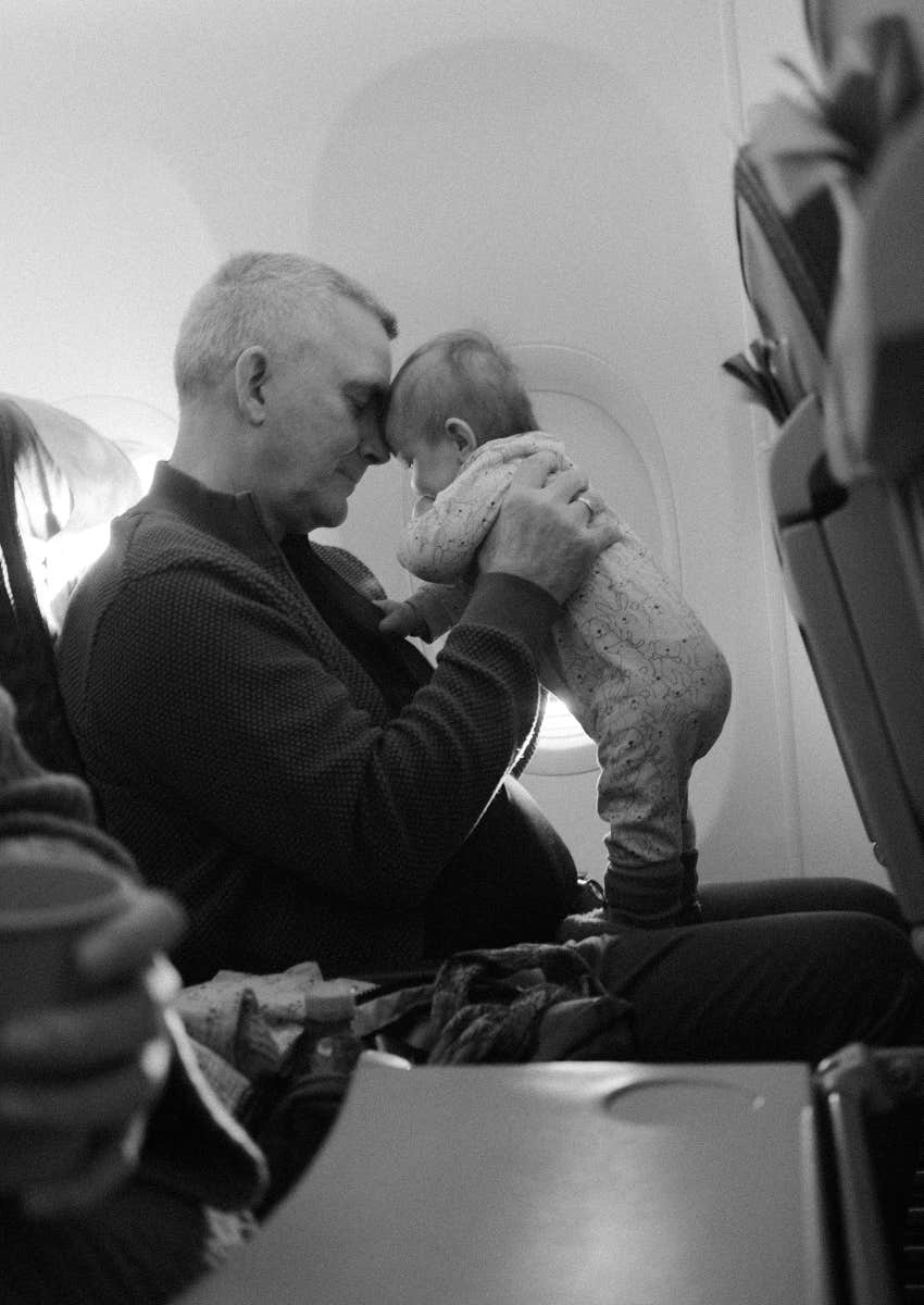 Mom Flying With Her Baby Told That Babies Aren't Allowed In Business Class dad holding his baby while flying