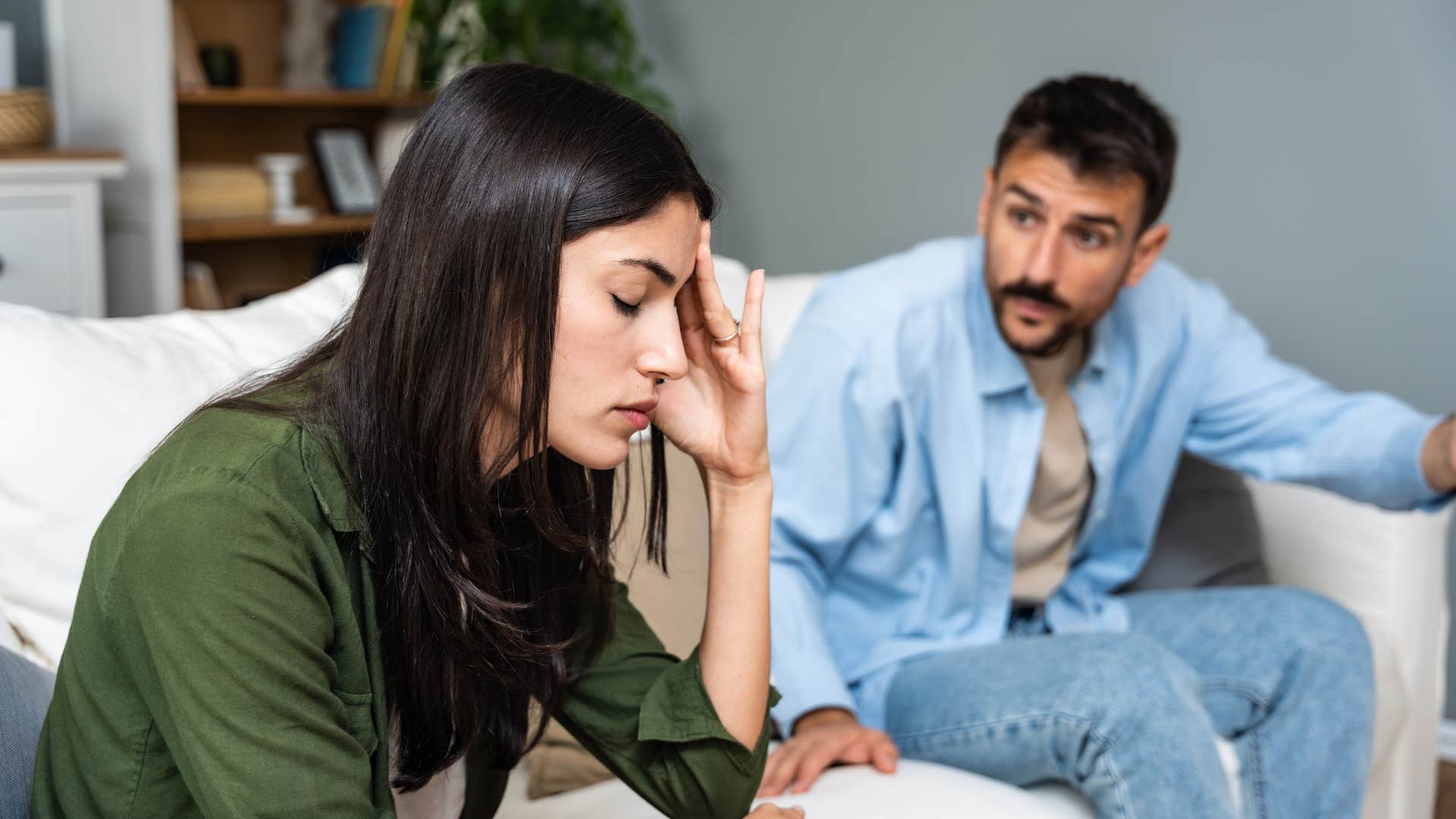 young couple having argument on couch at home