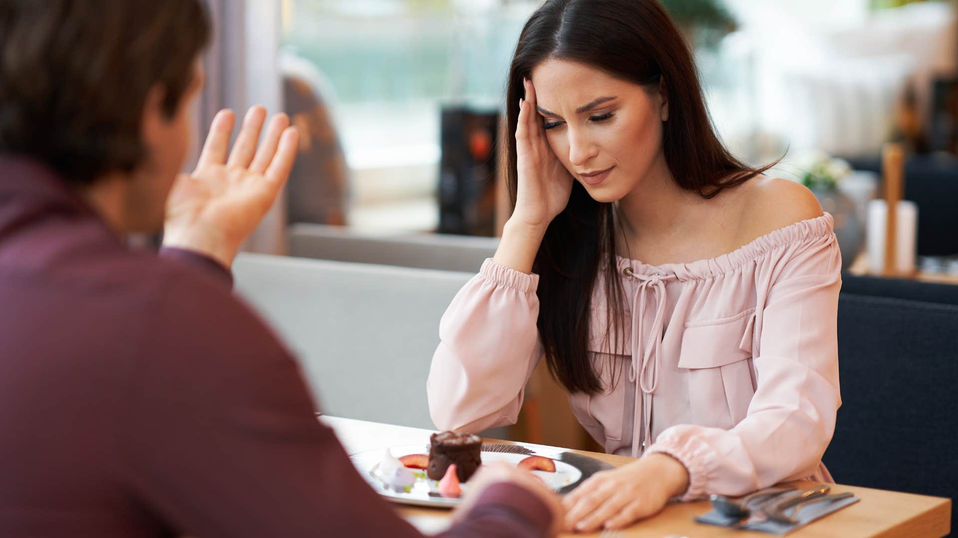 frustrated woman arguing with partner in cafe