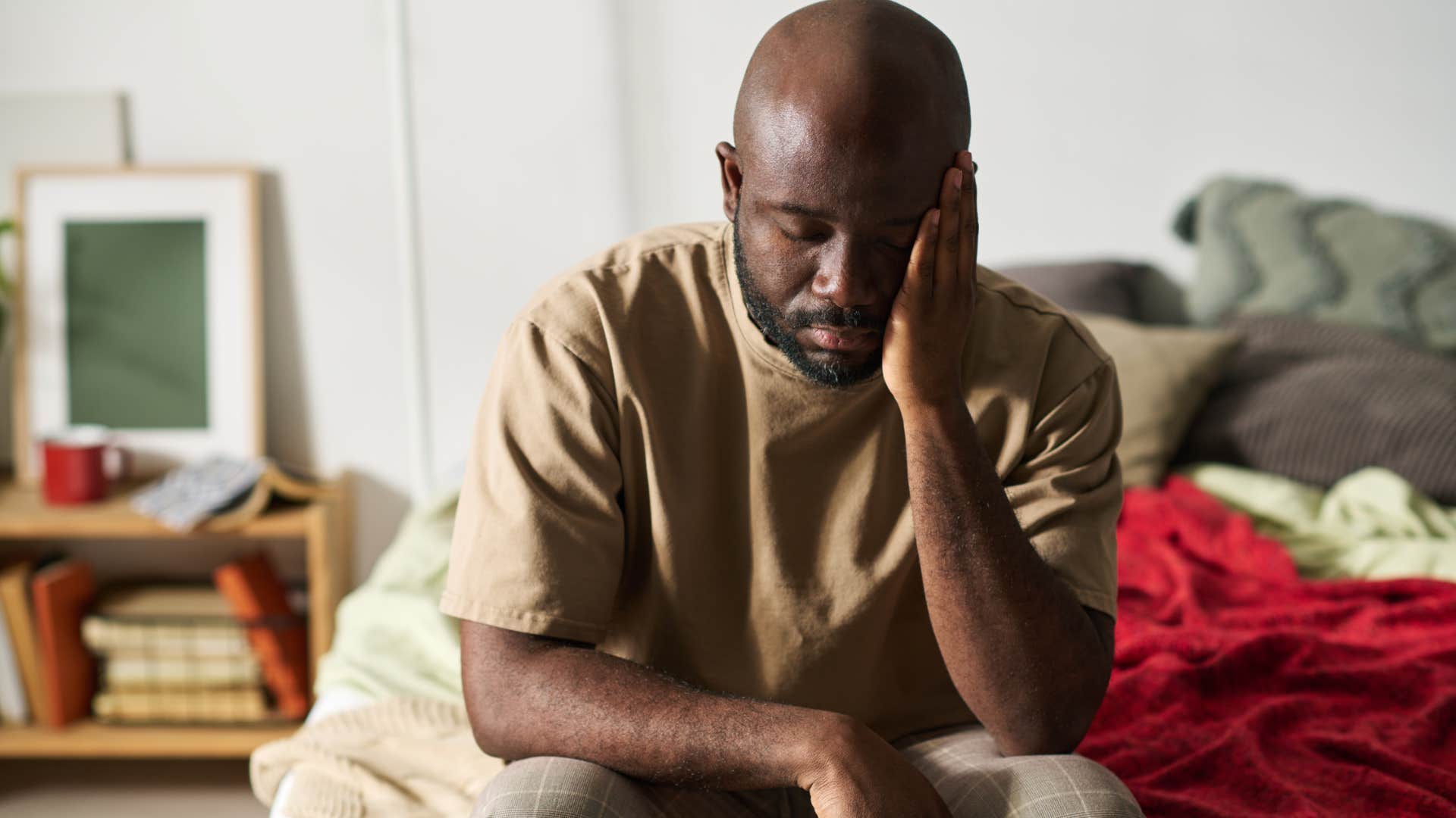 sad man sitting on unwashed sheets