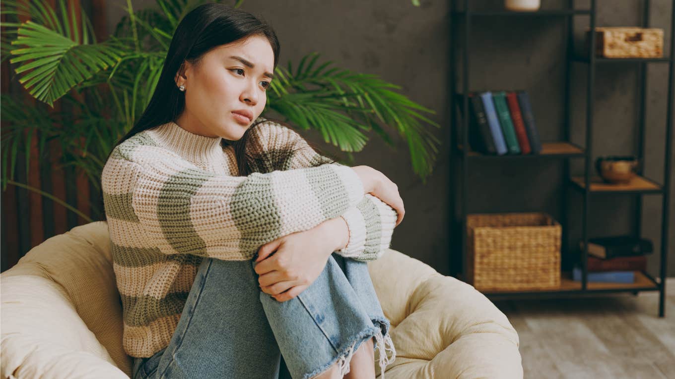 If You Notice These Things In Someone's House, They're Likely In Some Sort Of Financial Distress woman in financial distress sitting in her living room