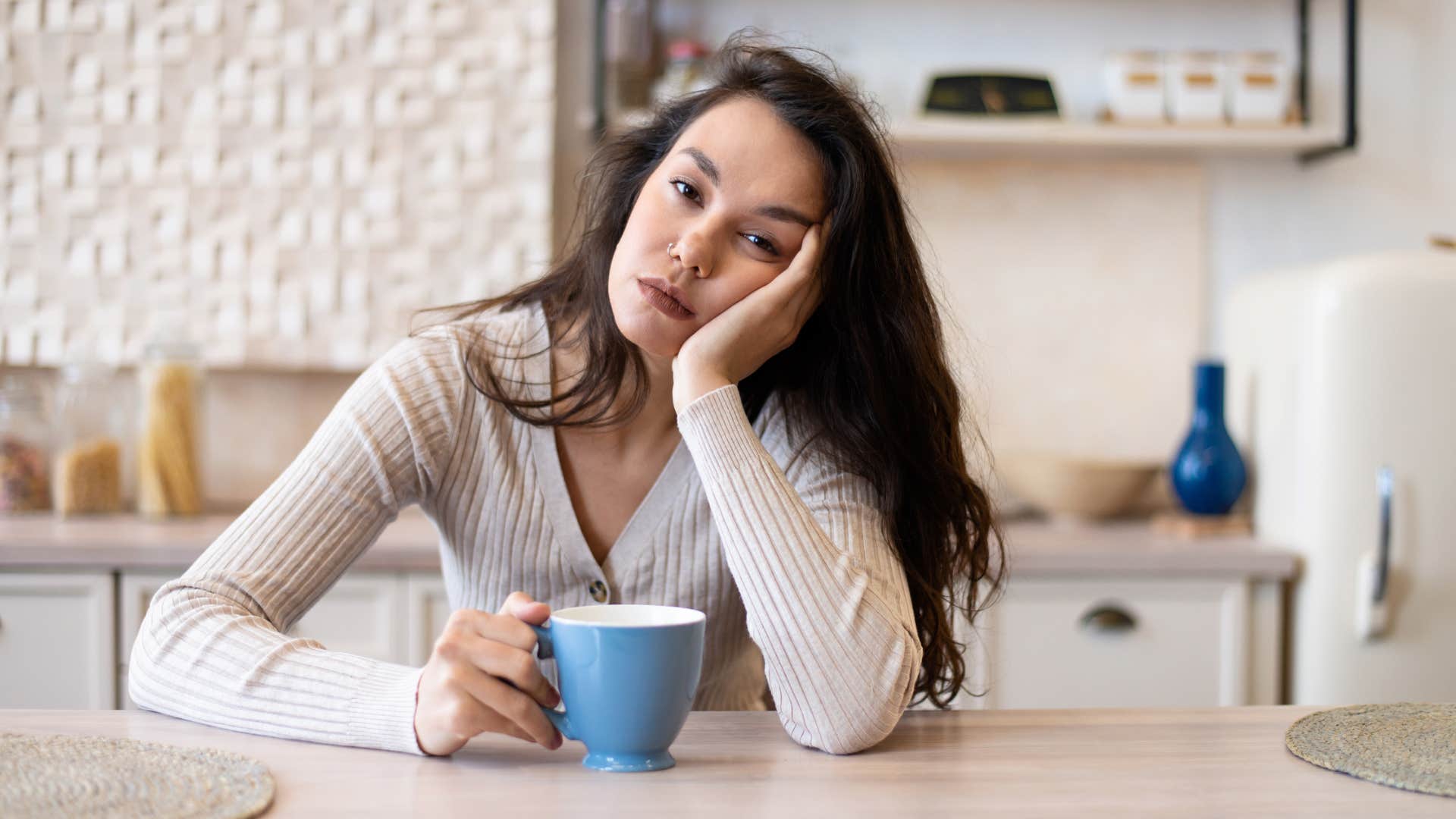 stressed sad woman drinking instant coffee in her kitchen