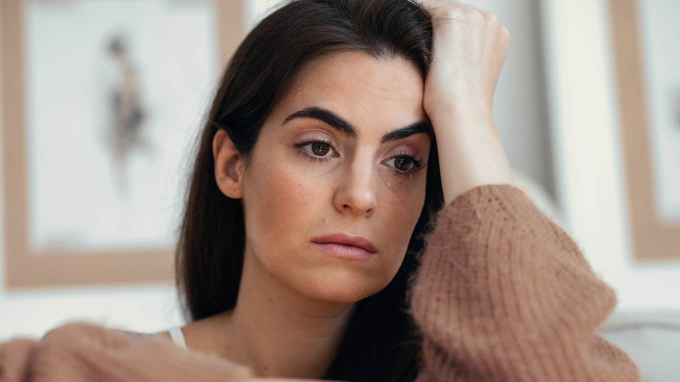 exhausted woman sitting at home thinking