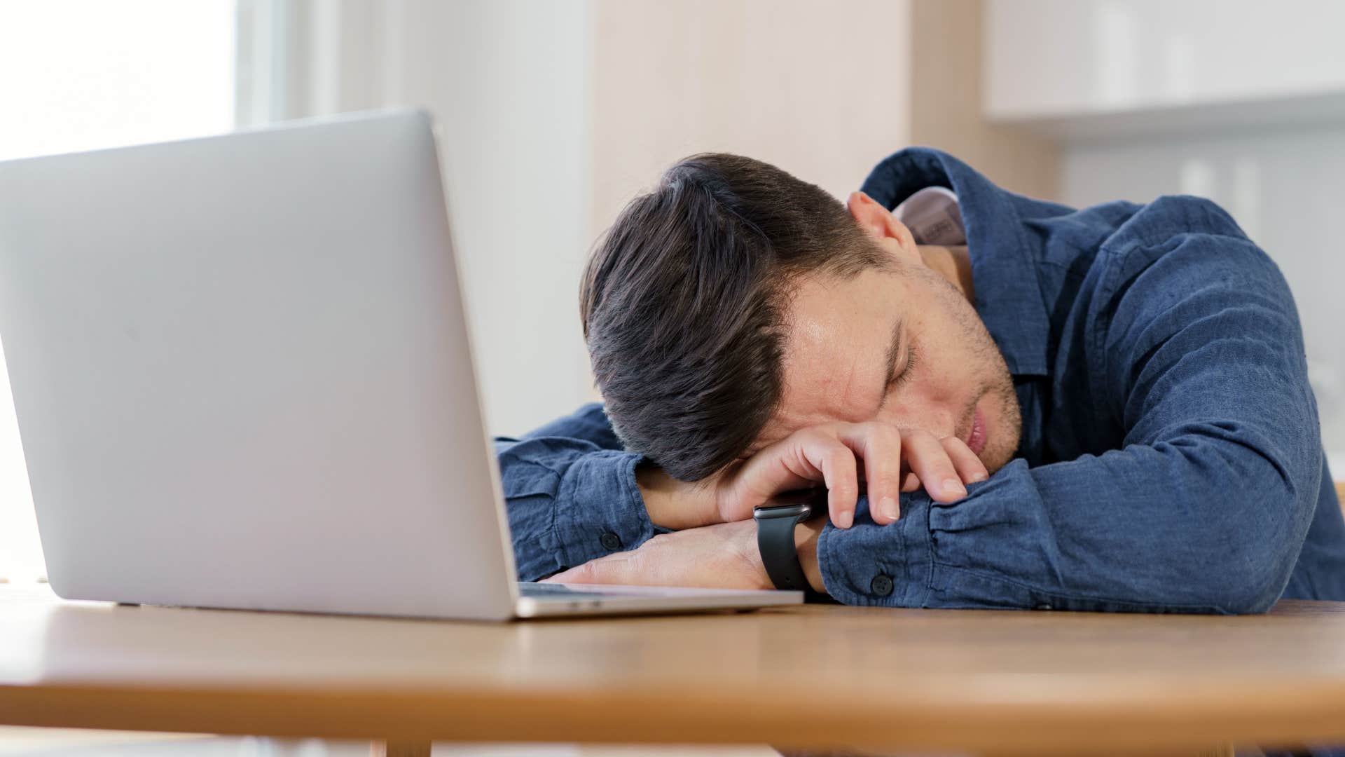 exhausted man ignoring his half-completed projects