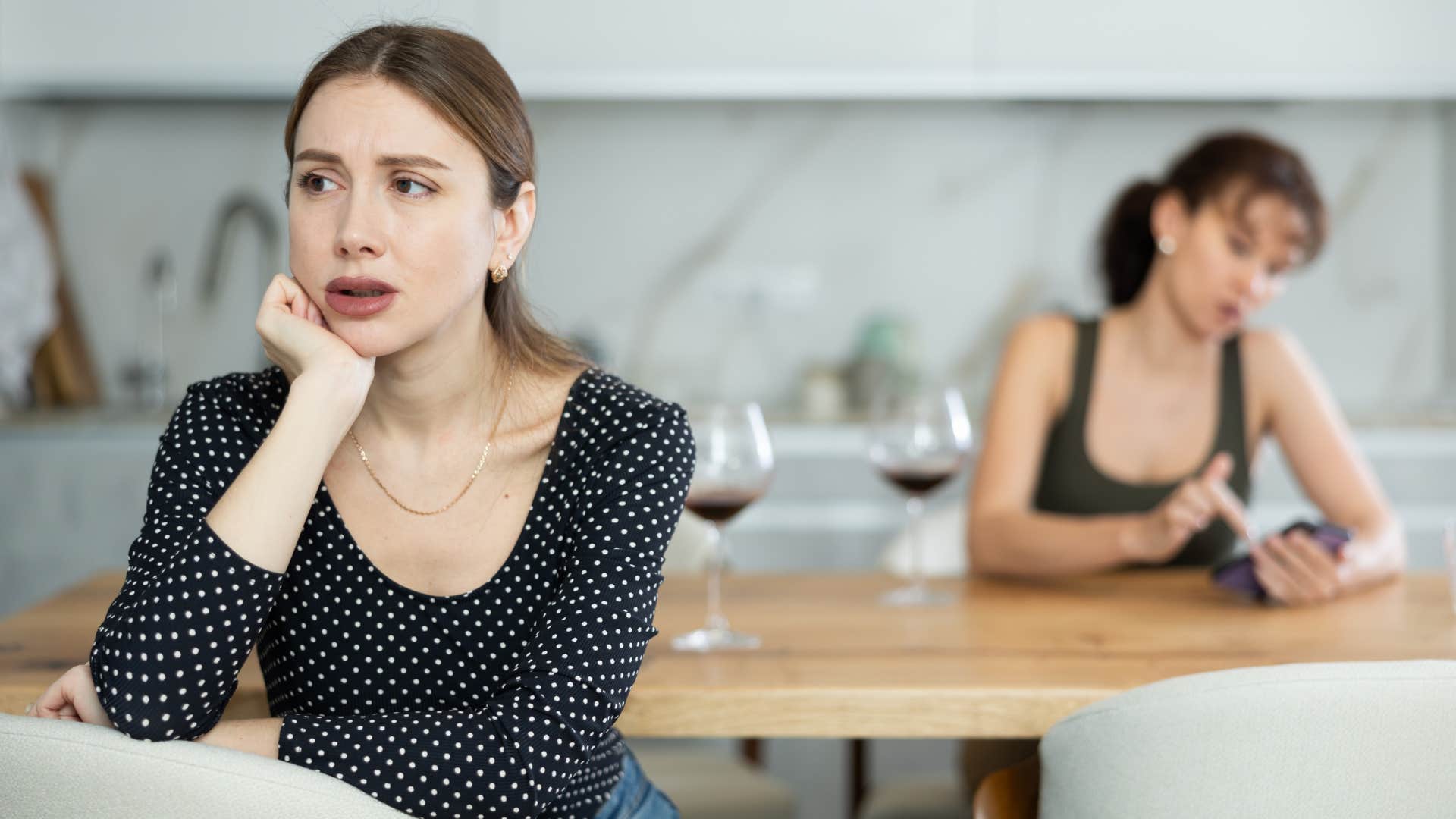 two women have unpleasant conversation in dining room