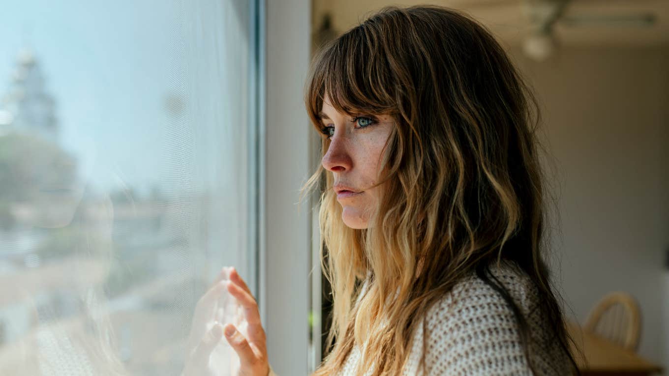 People Who Crave Deep Connection But Need Endless Alone Time Usually Have These Reasons woman looking out the window craving connection but needing alone time