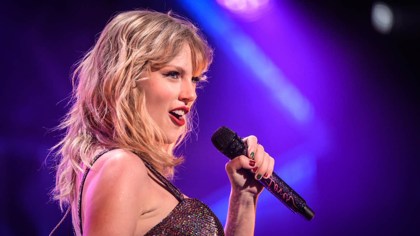 taylor swift holding a microphone singing on stage