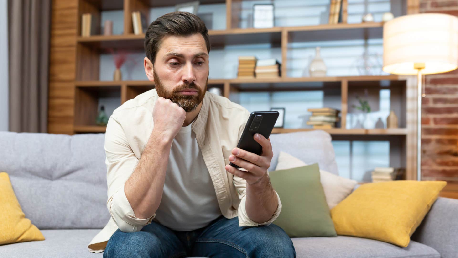 annoyed man looking at phone bombarded with taylor swift news
