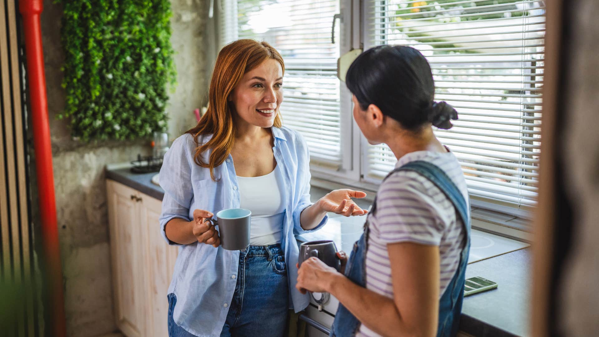 woman in blue cardigan smiling and asking strange questions to woman