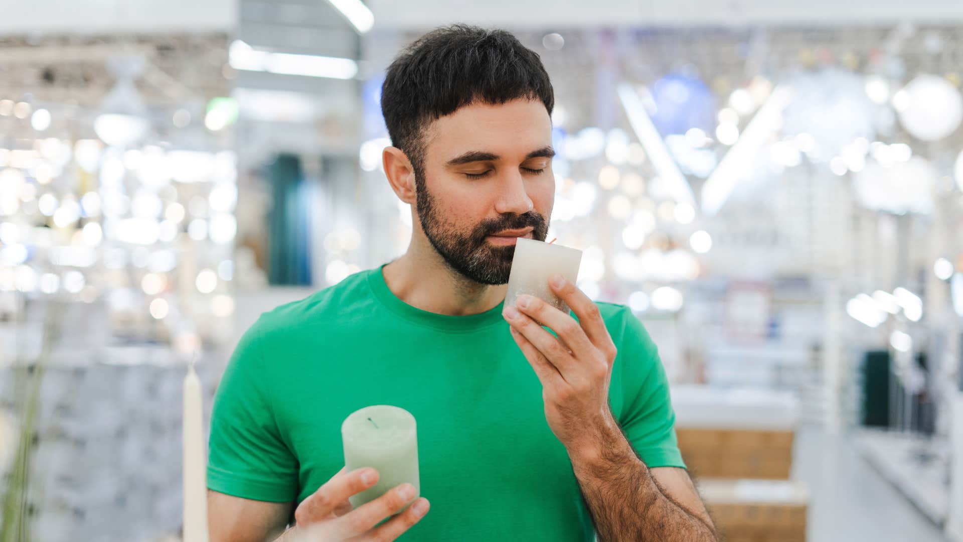 man smelling candles at the store