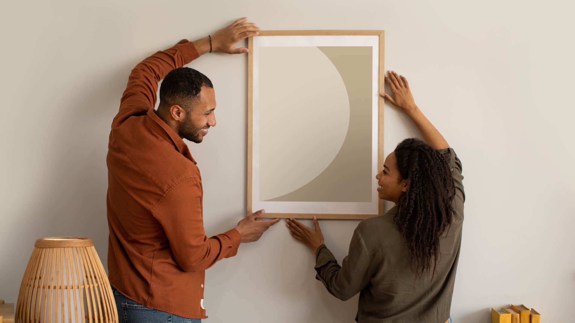 couple hanging up framed art together