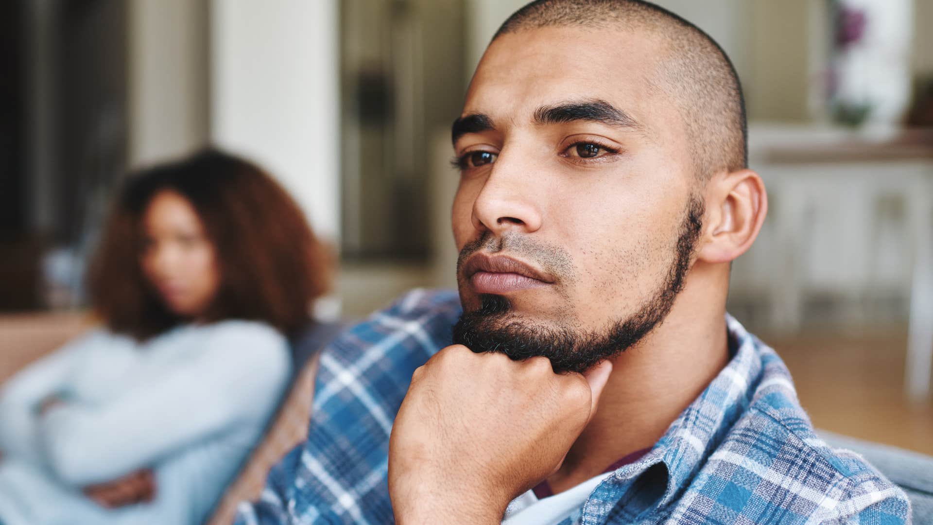 introspective man turned away from his wife at home