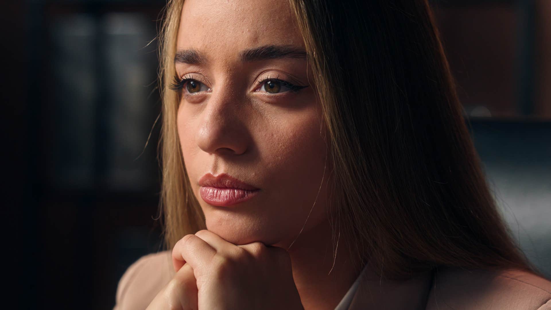 realistic woman sitting at home thinking