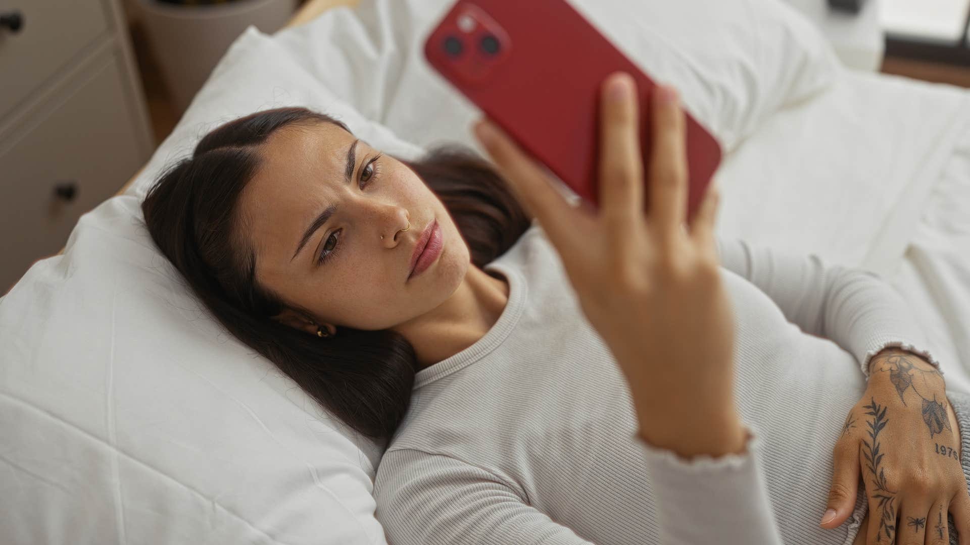 woman looking at her phone in bed
