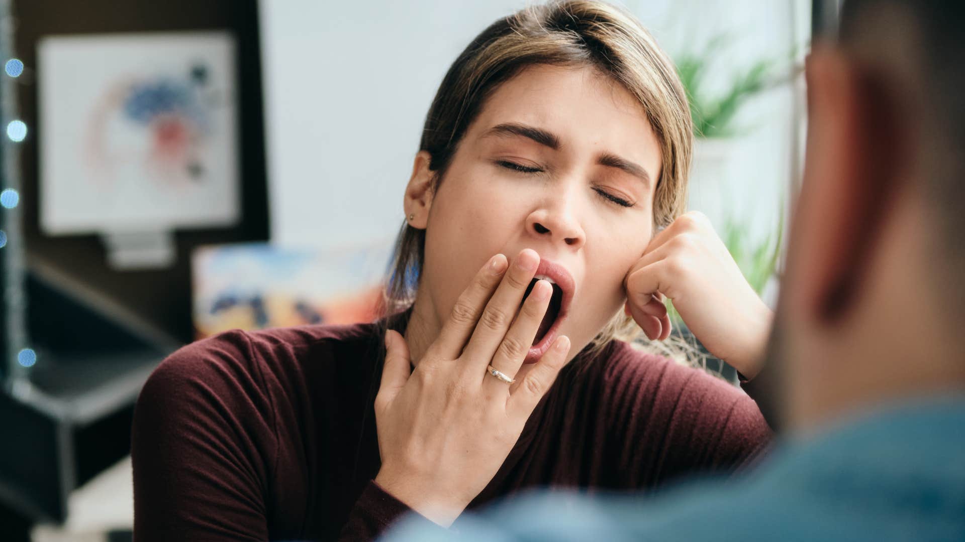 woman yawning during conversation
