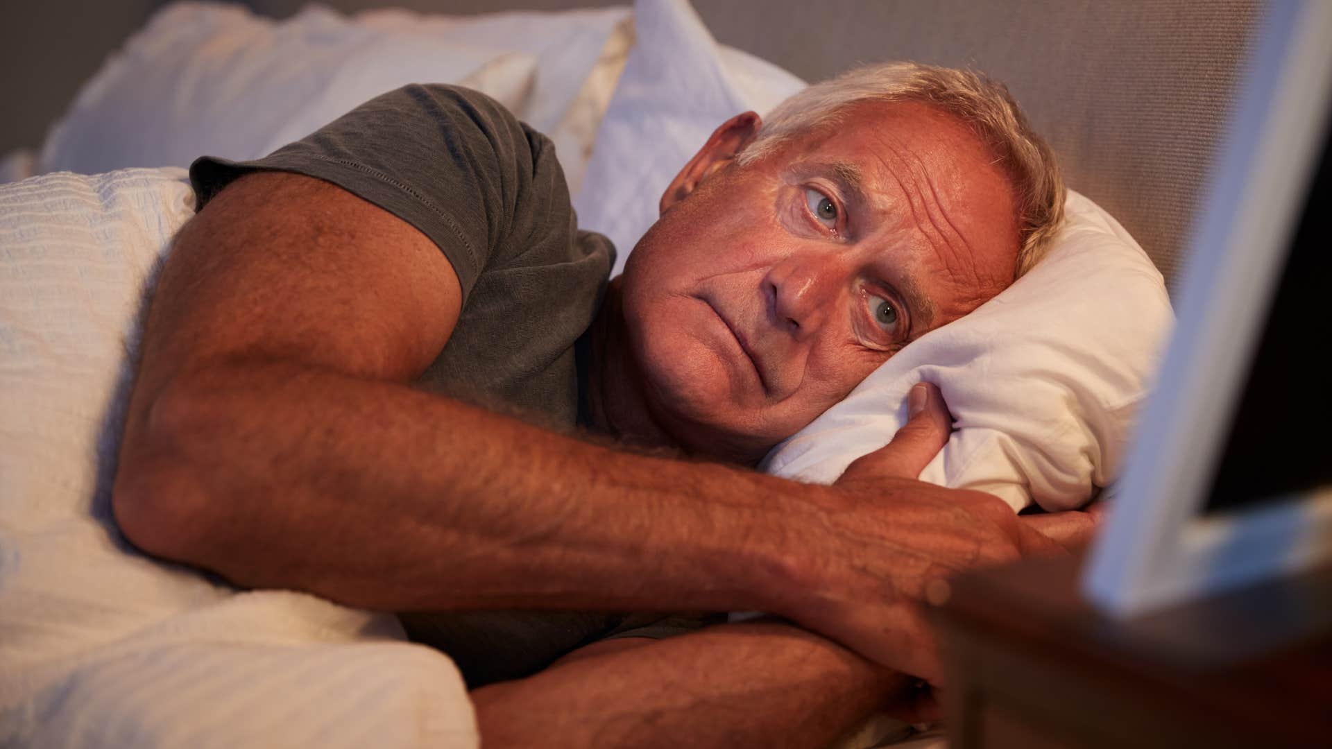 man sleeping with one foot out because it's a childhood habit