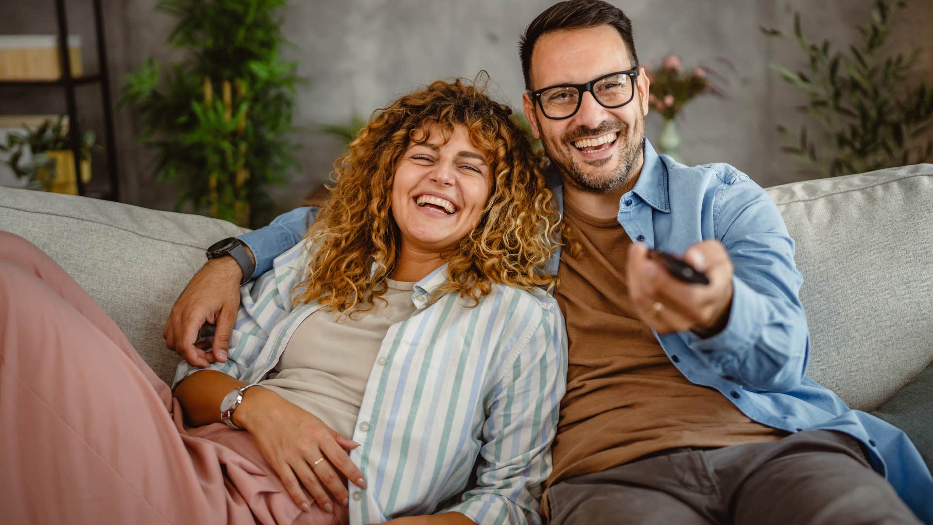 woman smiling with her husband on the couch