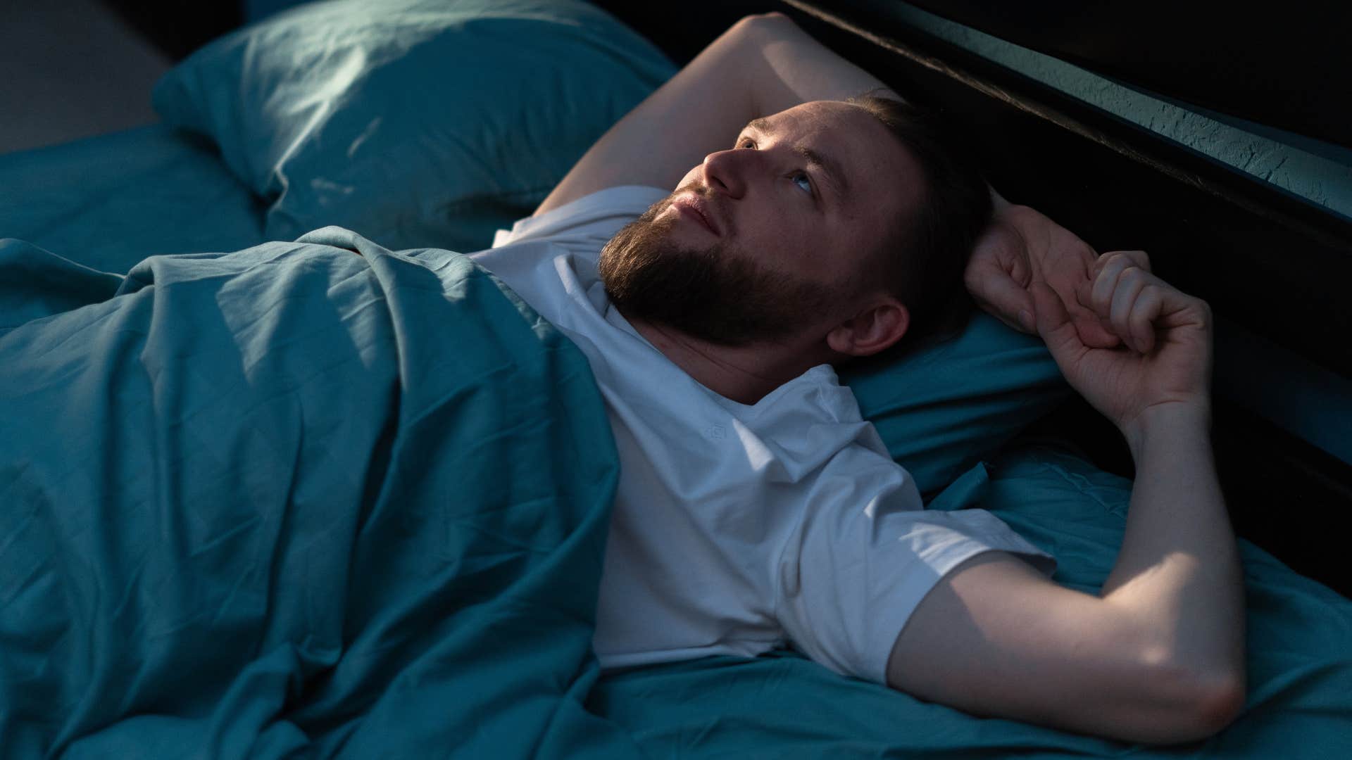 man who has restless legs laying in bed