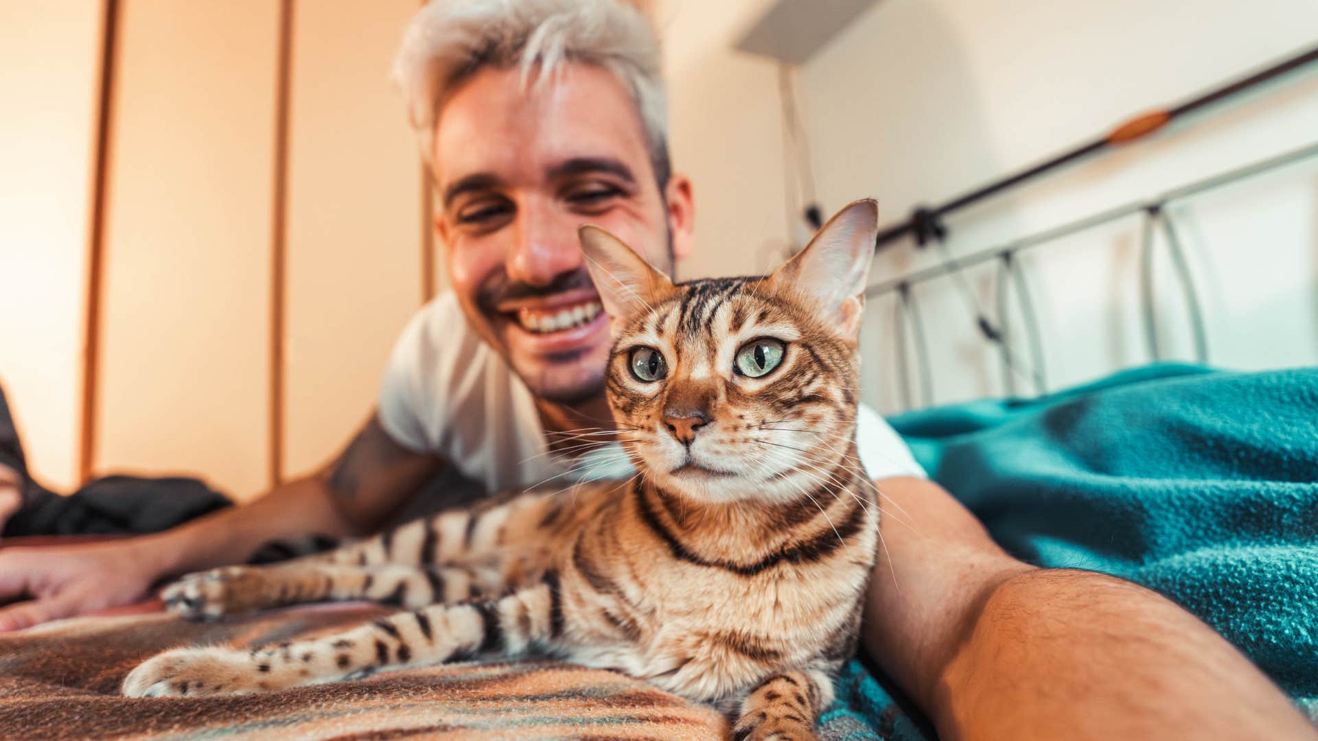 Man lying with his cat after it's become a routine.