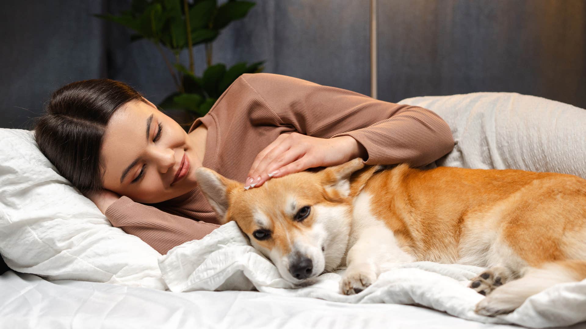 Woman whose pet helps them cope with insomnia in bed.