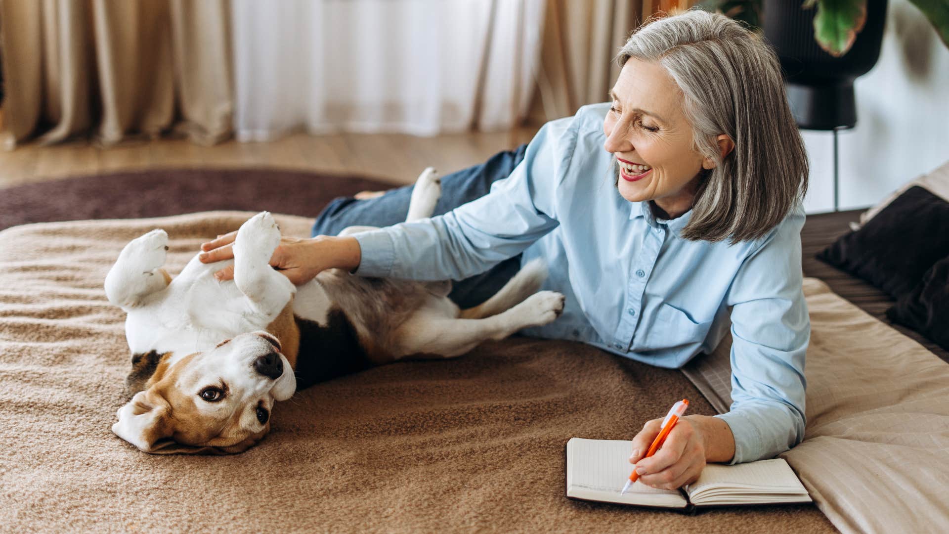 Woman whose pet is their child smiling in bed.