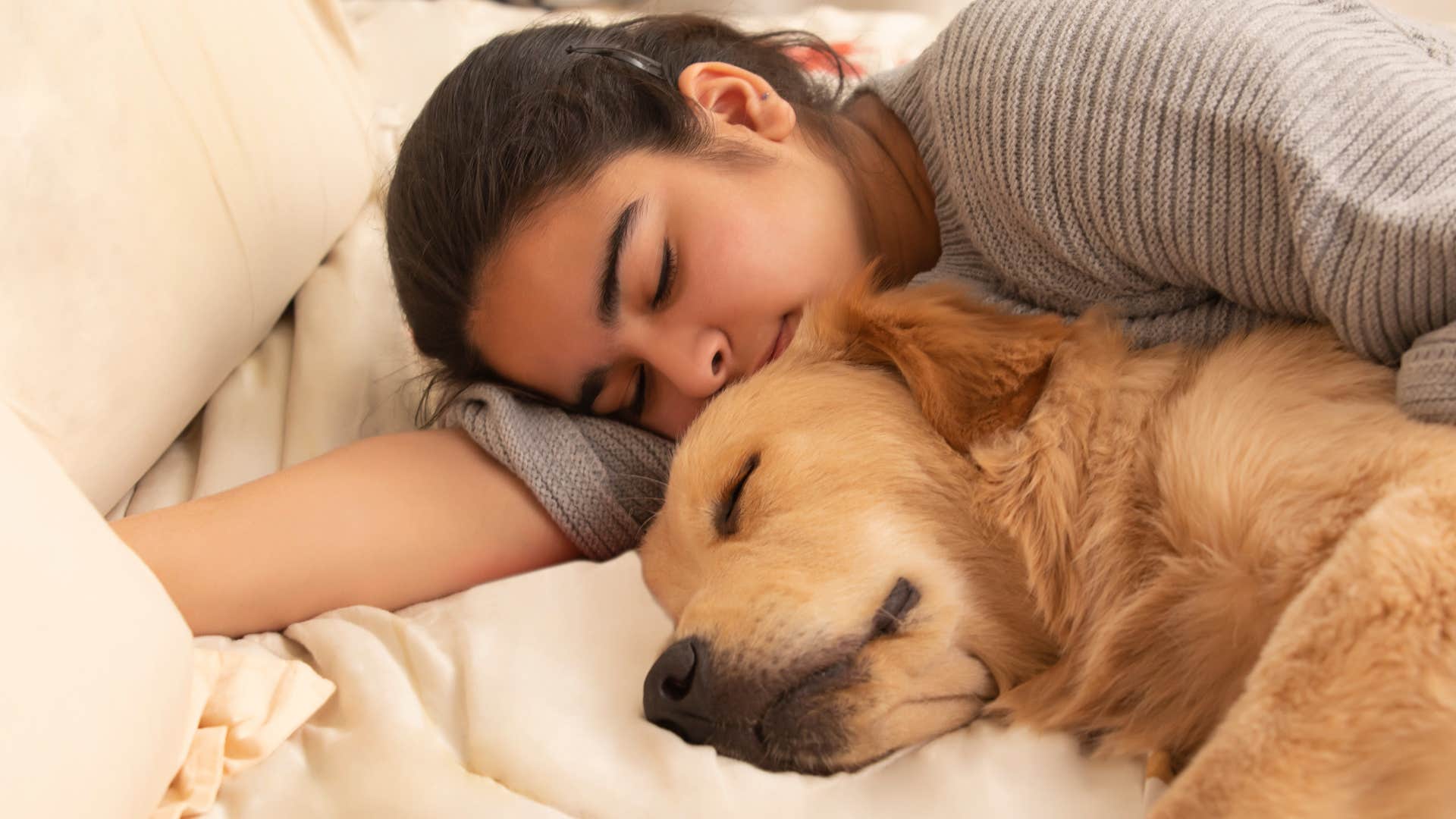 Woman lying with her pet who has separation anxiety.