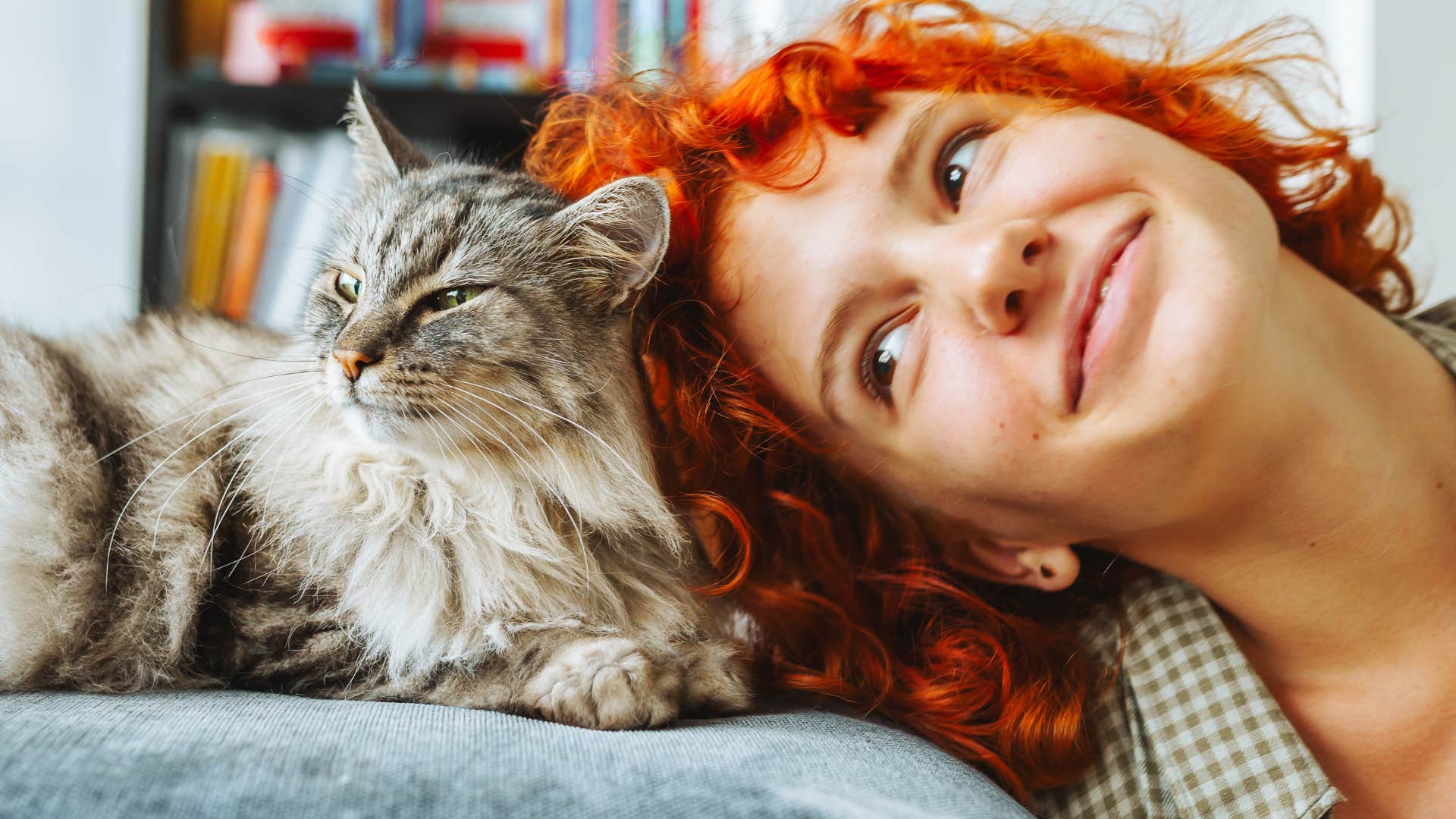 Touch-deprived woman smiling with her cat.