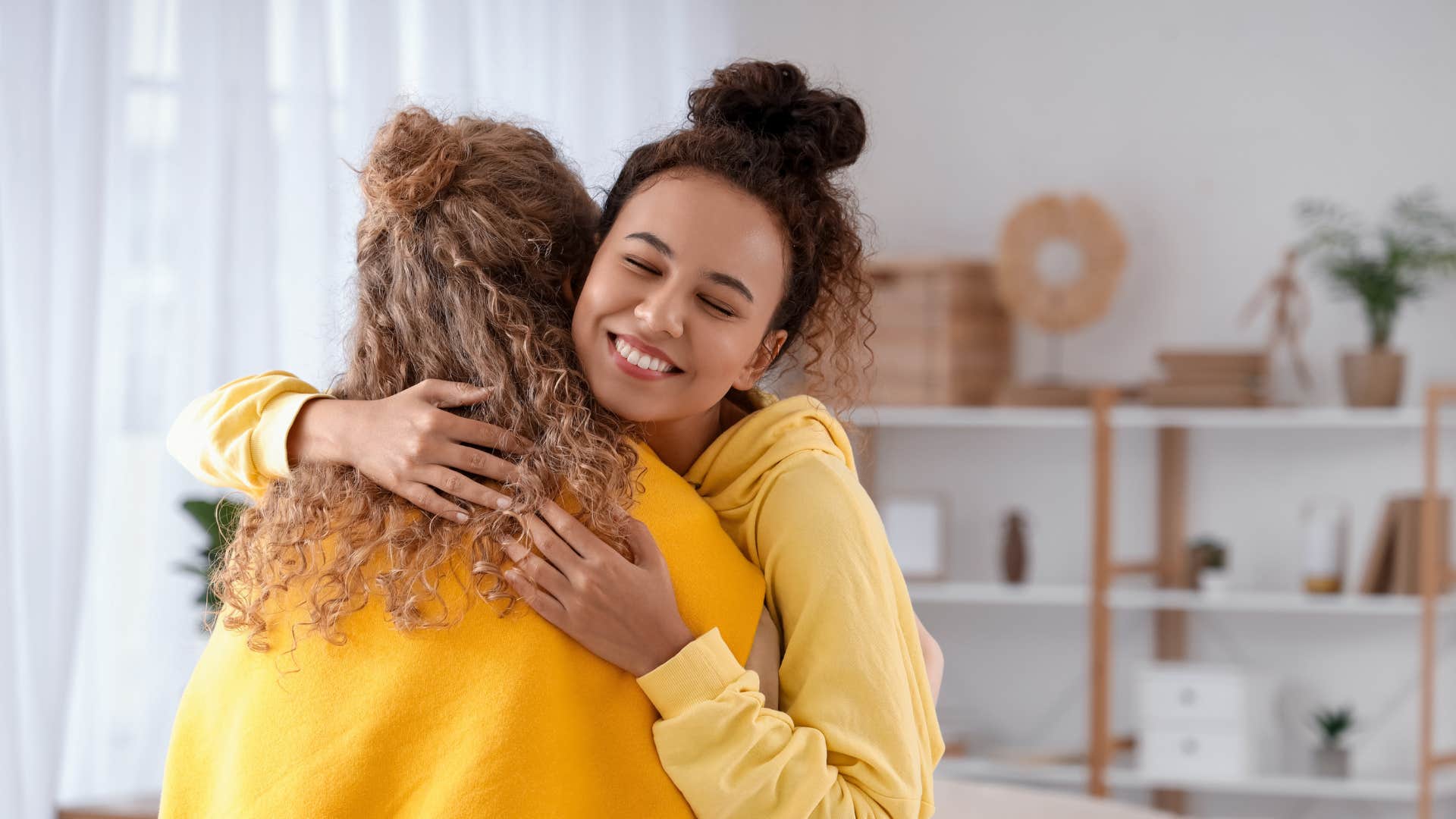two friends in yellow hugging as they create a peaceful home