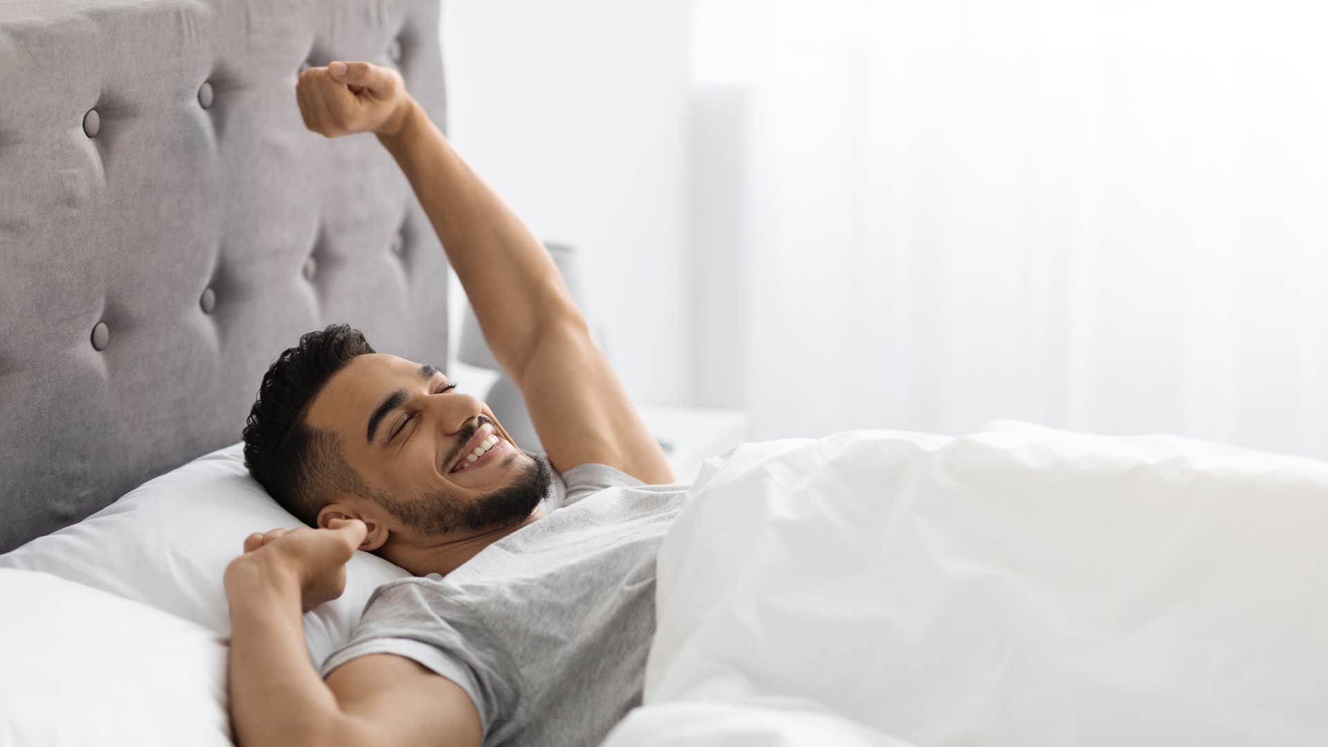 man in gray shirt waking up to a slow morning